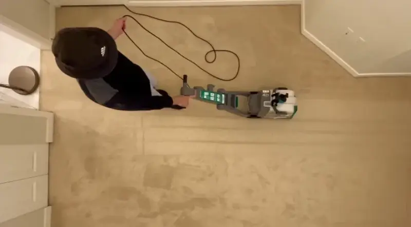 Overhead view of technician cleaning carpet in a New York hallway