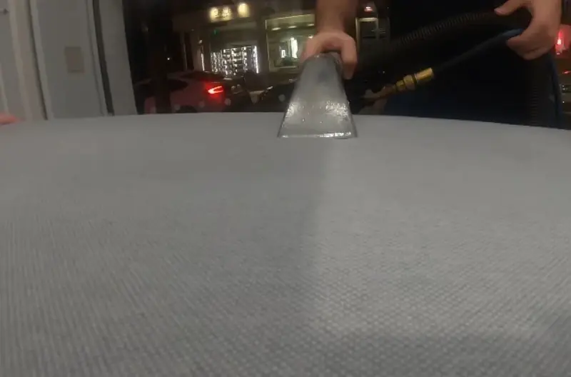 Close-up of extraction tool cleaning fabric texture
